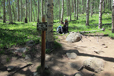HIker sitting at the junction with the Colorado Trail.