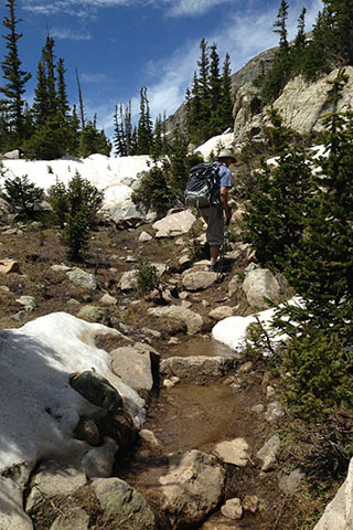 Trail wet from snow melt as it is  heading toward Pear Lake
