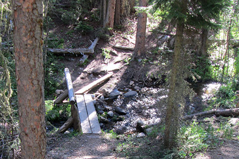 looking down at a footbridge over a small creek