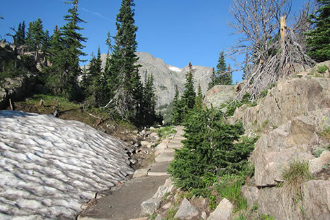Just below The Loch, the trail passes between a snow bank and rocks