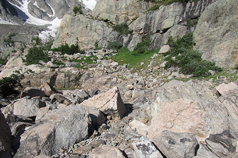 Trail crossing stepping stones through rocky terrain