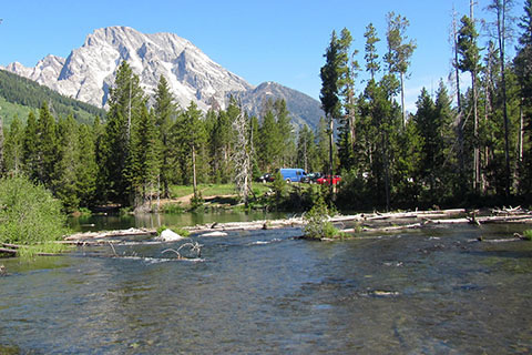 Vehicles parked seen at the String Lake Trailhead with Mount Moran in the background