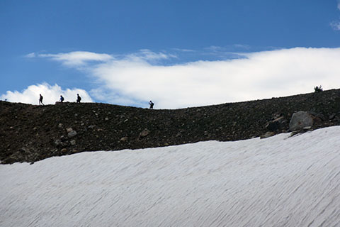 HIkers above snowfield on the Paintbrush Divide